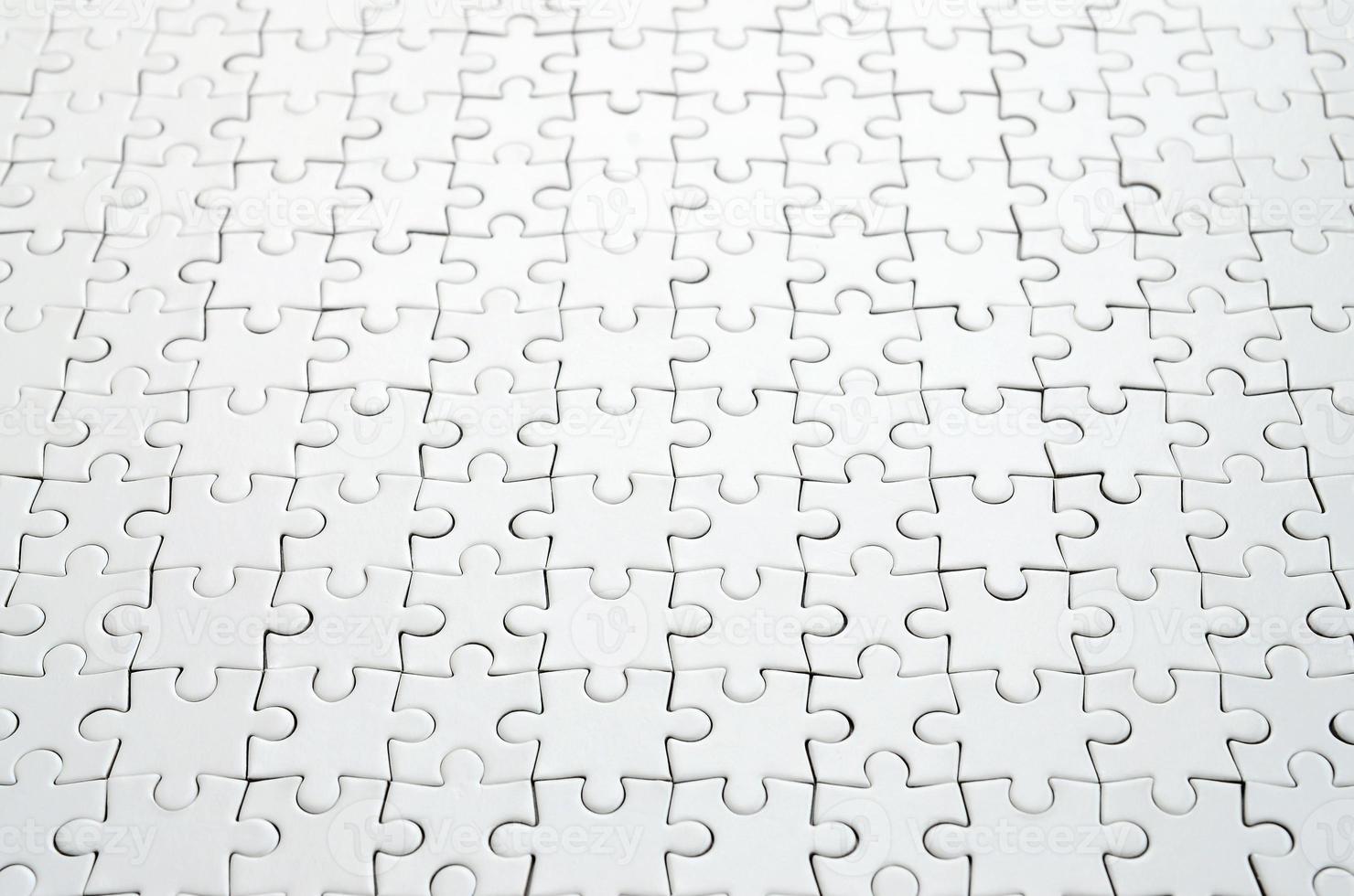 gros plan d'un puzzle blanc à l'état assemblé en perspective. de nombreux composants d'une grande mosaïque entière sont unis photo