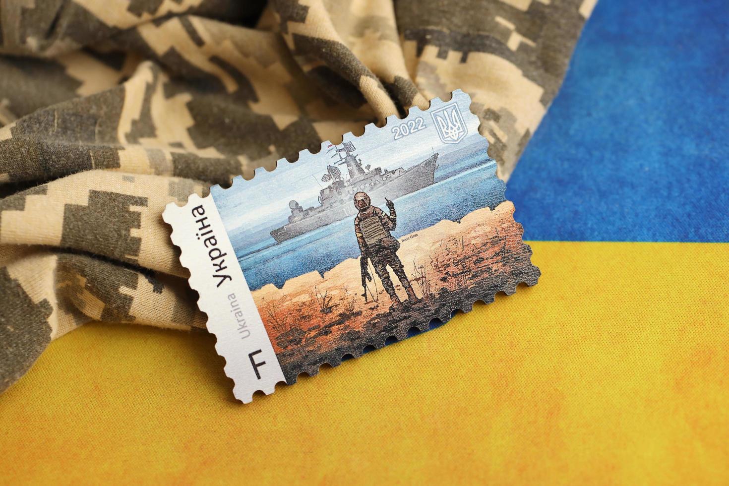 ternopil, ukraine - 2 septembre 2022 célèbre cachet postal ukrainien avec un navire de guerre russe et un soldat ukrainien comme souvenir en bois sur l'uniforme de camouflage de l'armée et le drapeau national photo