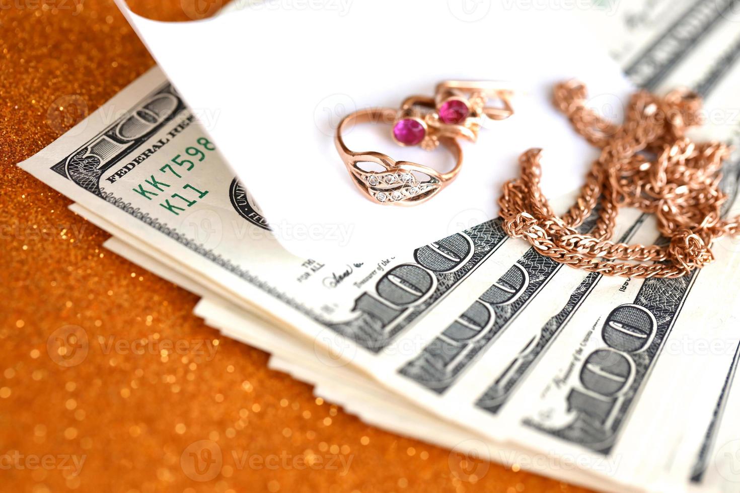 bague, boucles d'oreilles et collier de bijoux dorés coûteux avec une grande quantité de billets d'un dollar américain sur une surface de fond dorée scintillante de luxe. prêteur sur gages ou bijouterie photo