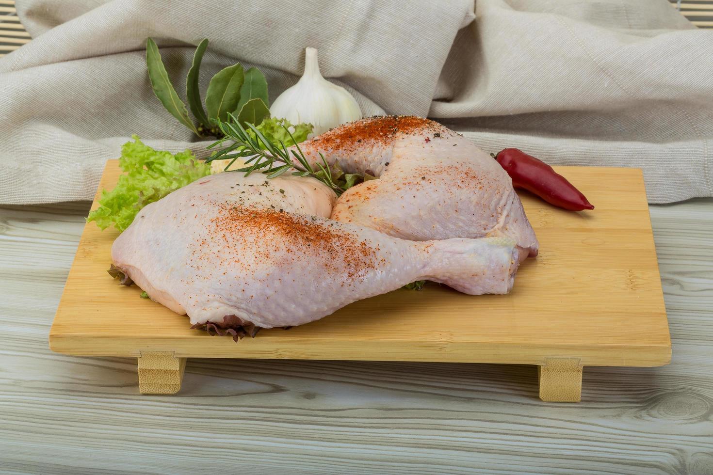 cuisse de poulet sur planche de bois et fond en bois photo