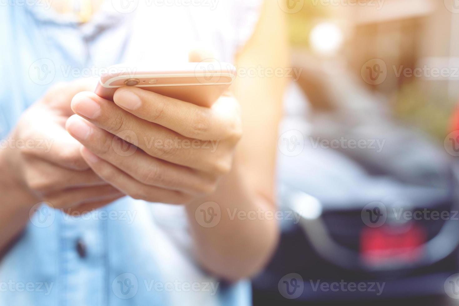 gros plan main personnes femme debout à l'aide du téléphone intelligent mobile sur le bord de la route. appeler un mécanicien automobile demander de l'aide car la voiture est en panne. photo