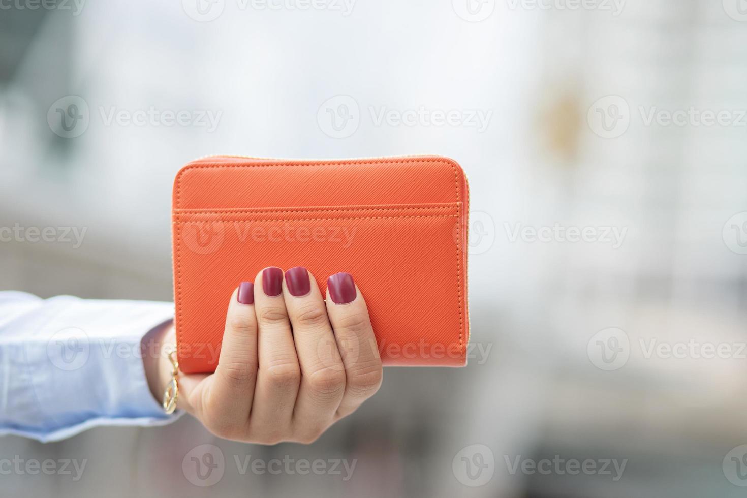 femme tenant un portefeuille de mode, elle fait ses courses dans un grand magasin. photo