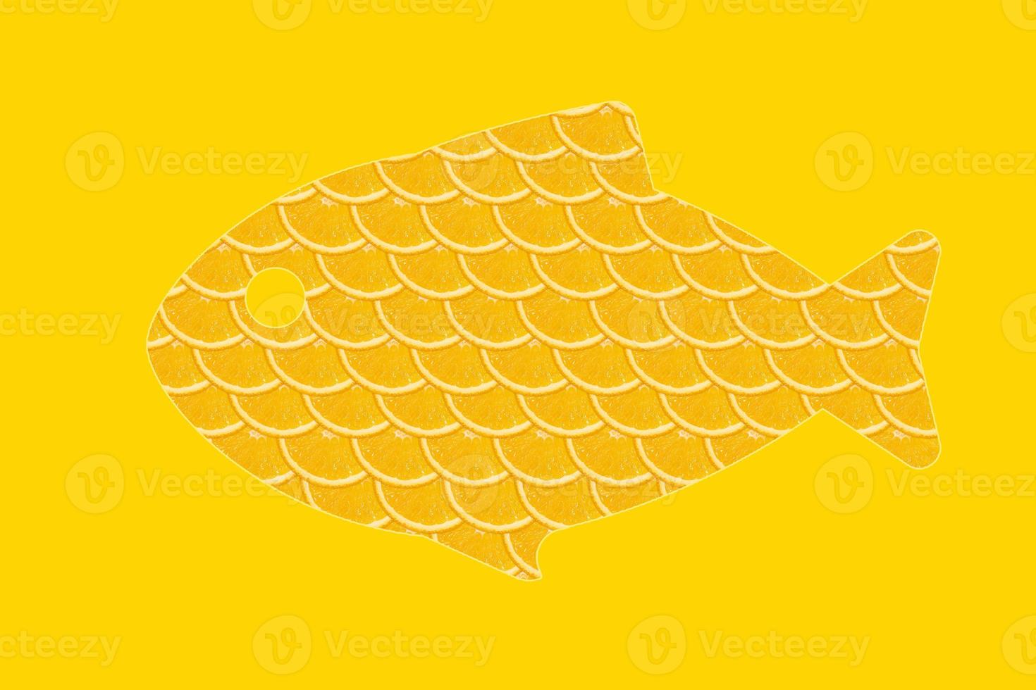 forme de poisson orange tranché, fond jaune photo