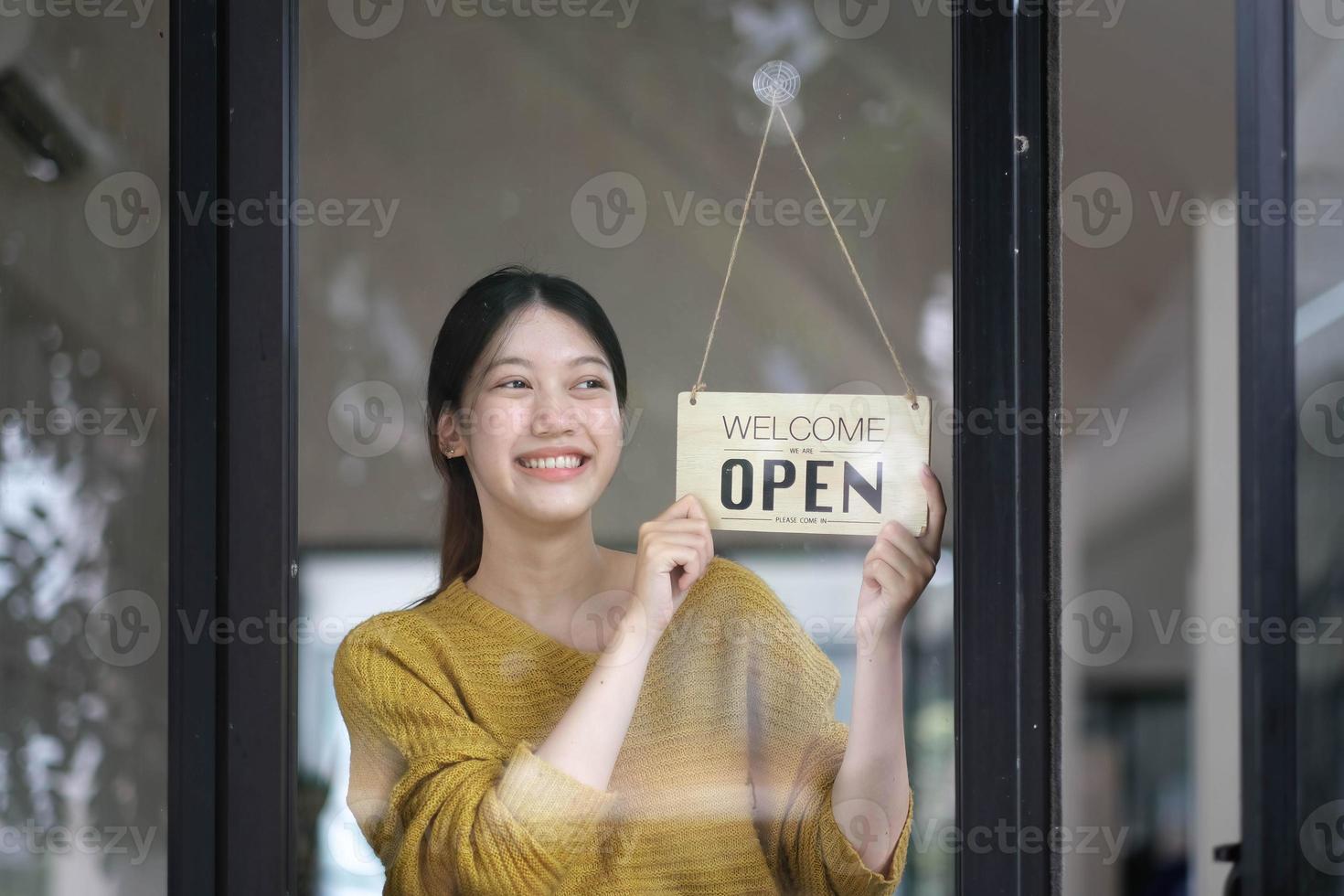 photo d'une jeune PME asiatique souriante propriétaire d'une petite entreprise portant un tablier et debout blanc ouvert singnear café porte, femme d'affaires asiatique barista café propriétaire PME entrepreneur vendeur concept