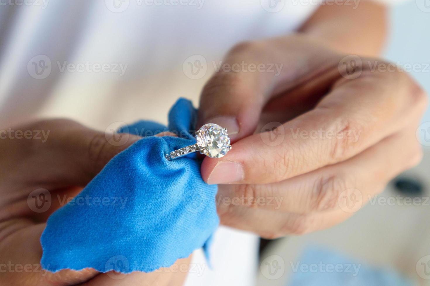 bijoutier polissage et nettoyage à la main bijoux bague en diamant avec tissu en microfibre photo