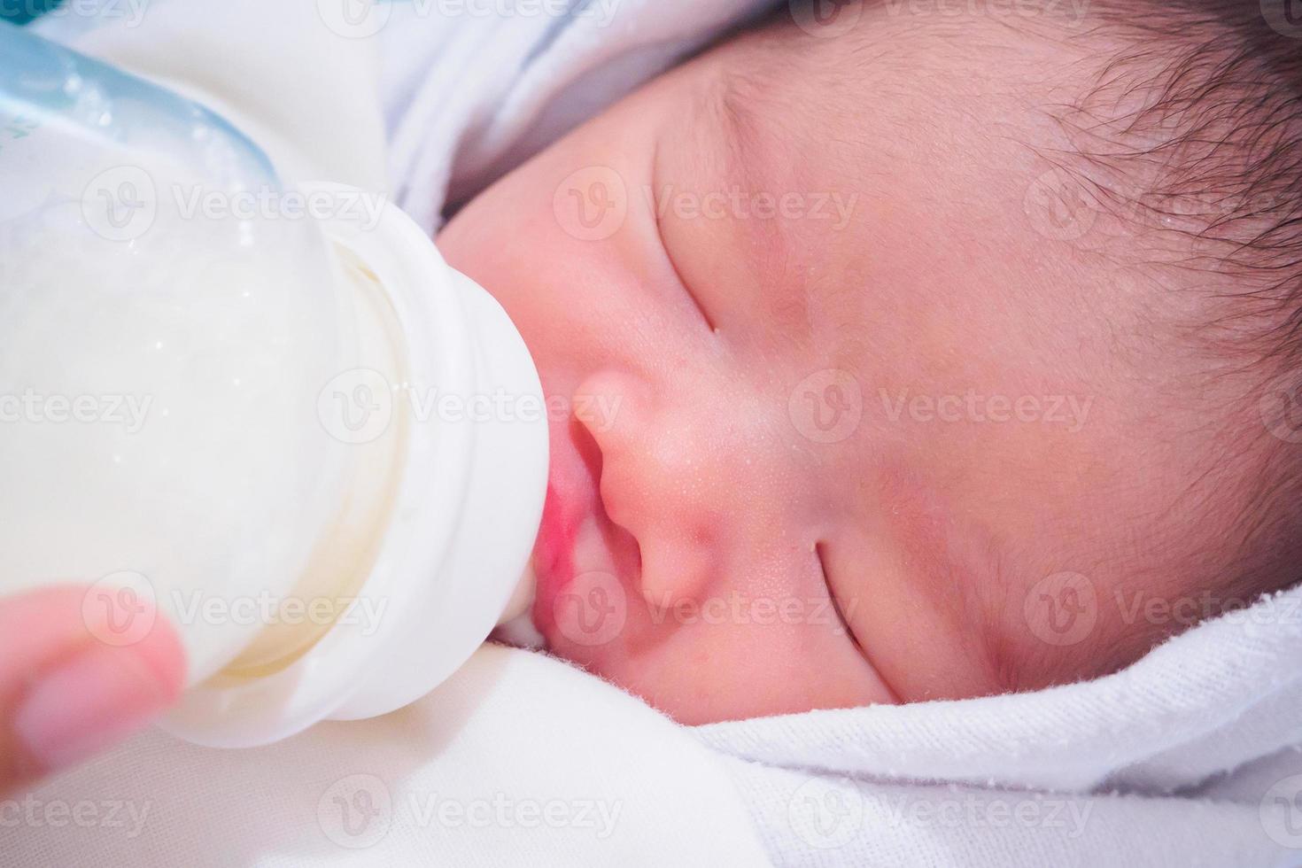 mère nourrissant bébé nouveau-né de la bouteille photo