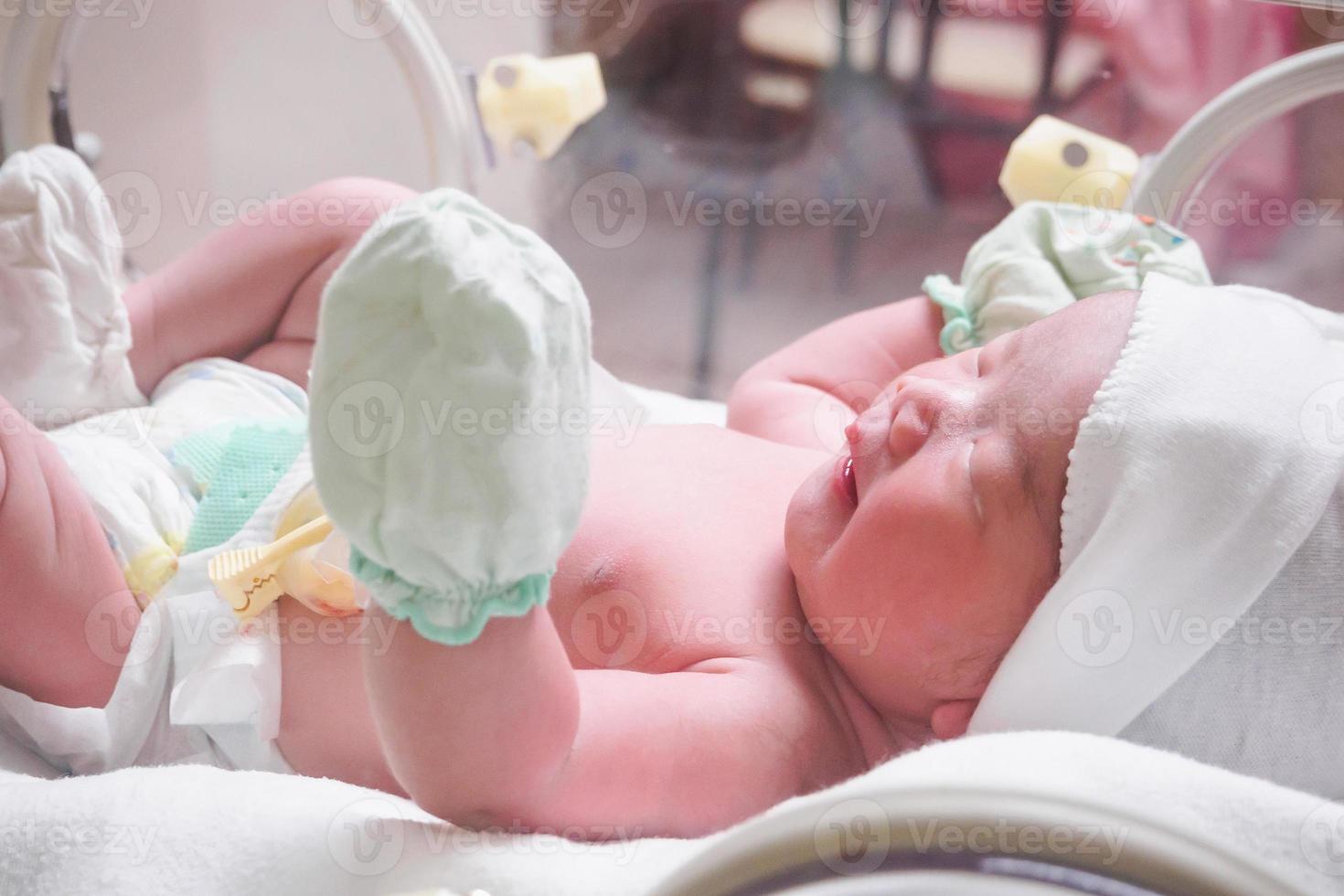 bébé nouveau-né à l'intérieur de l'incubateur dans la salle d'accouchement post-hôpital photo