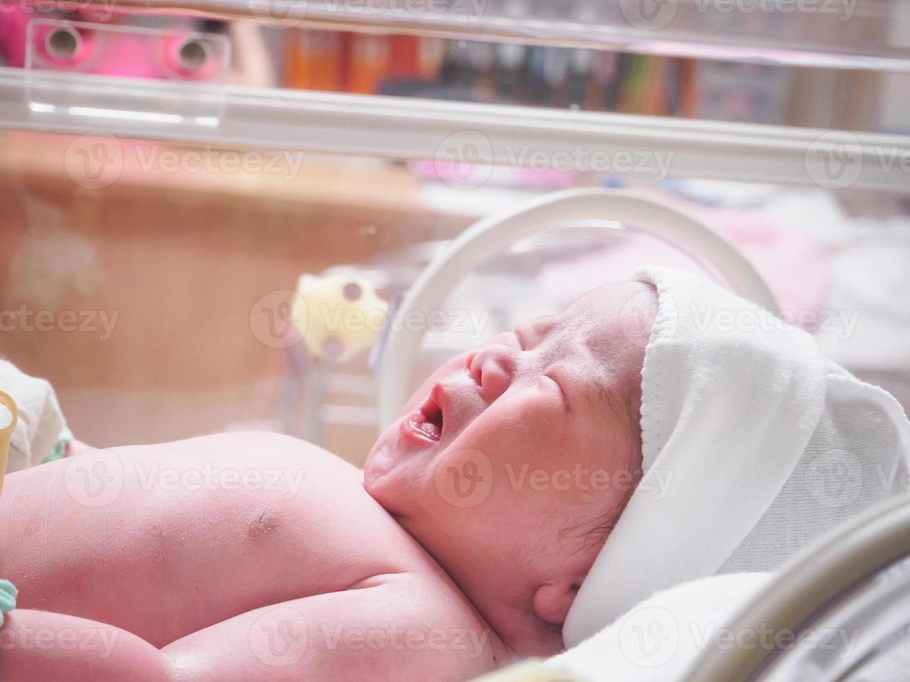 bébé nouveau-né à l'intérieur de l'incubateur dans la salle d'accouchement post-hôpital photo