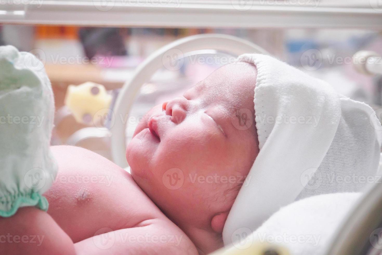 bébé nouveau-né à l'intérieur de l'incubateur dans la salle d'accouchement post-hôpital photo