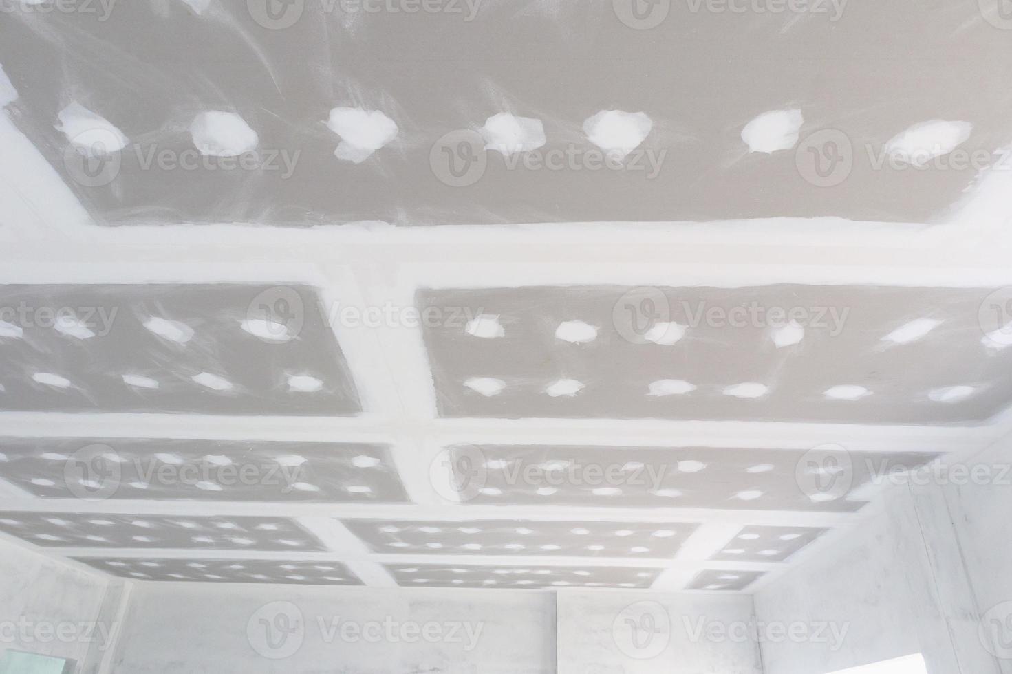 installation de plaques de plâtre au plafond sur un chantier de construction photo
