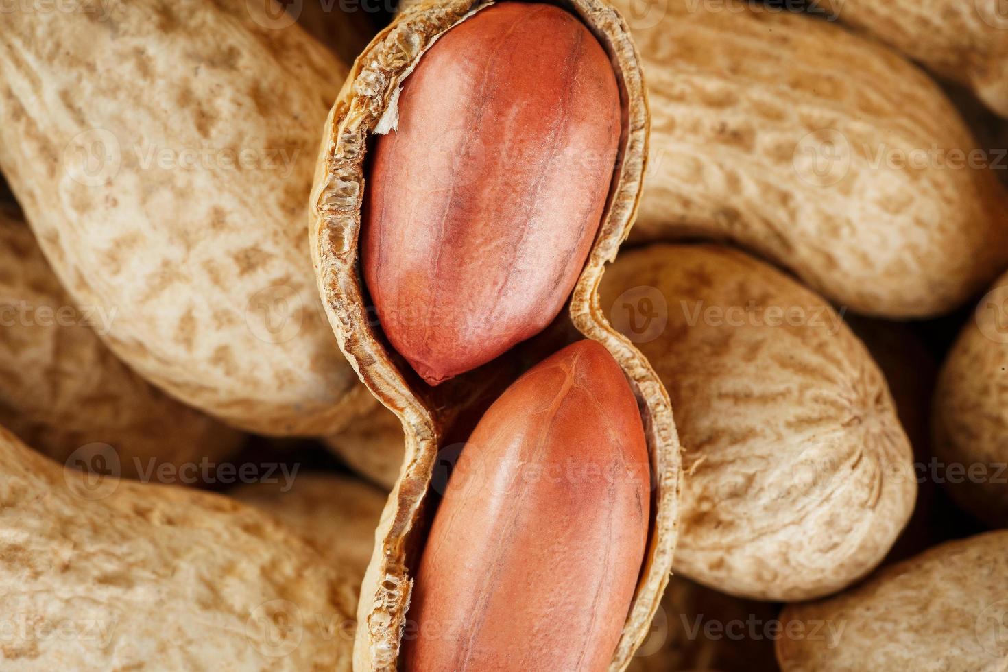 fruits d'arachide pelés sur fond d'arachides non pelées. photo