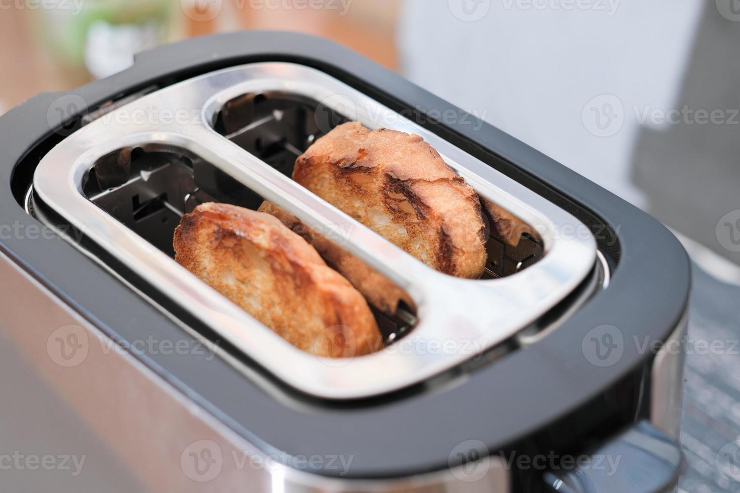 deux toasts prêts dans un grille-pain. pain croustillant prêt pour les sandwichs du matin. vue rapprochée photo