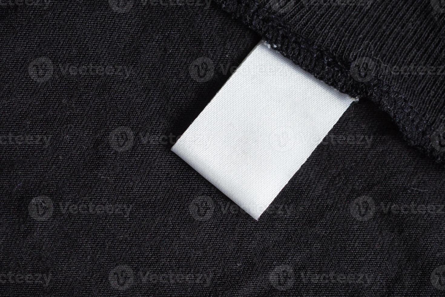 étiquette de vêtements de soin de lessive blanche vierge sur la texture du tissu noir photo