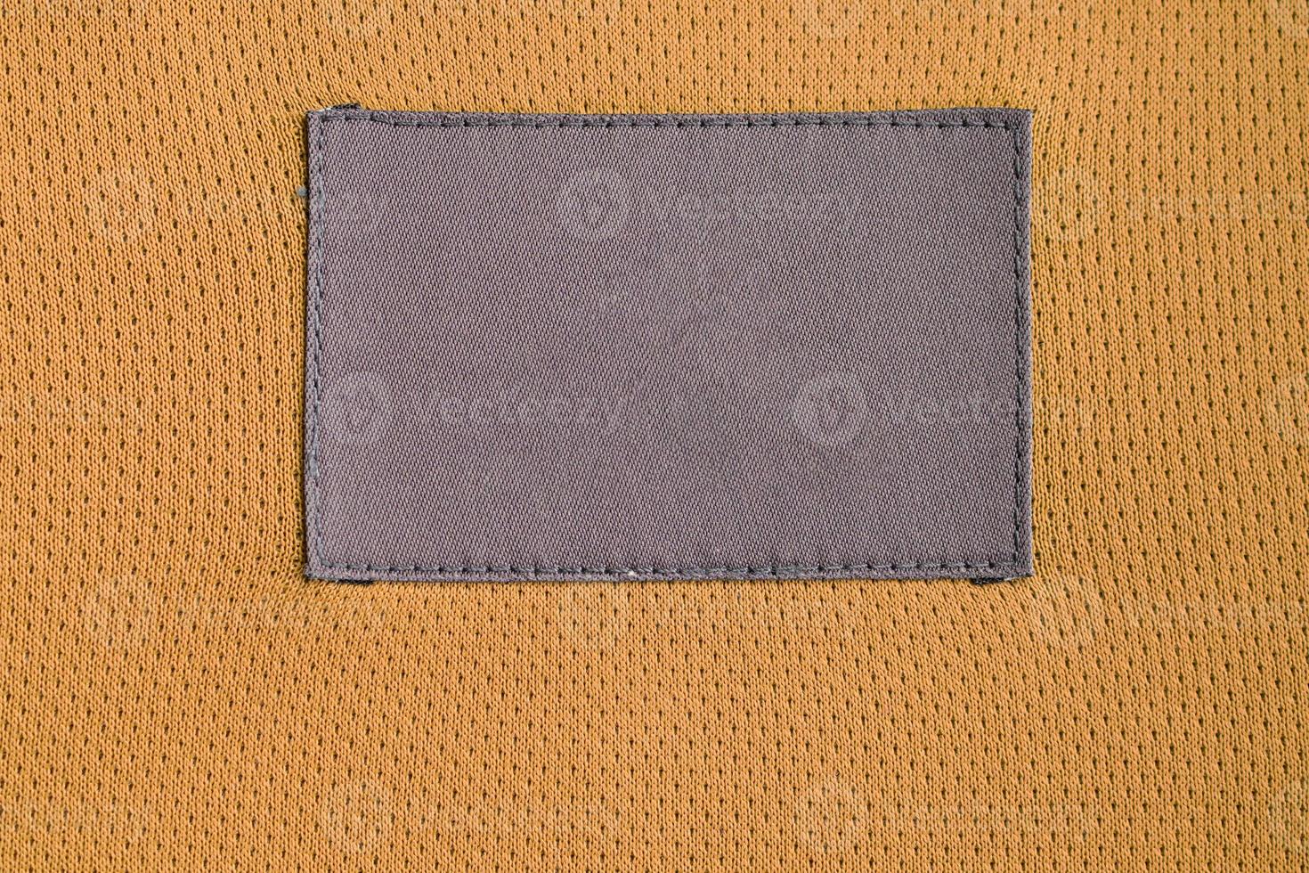 Patch d'étiquette de vêtements d'entretien du linge sur la texture de sport de jersey de tissu de polyester photo