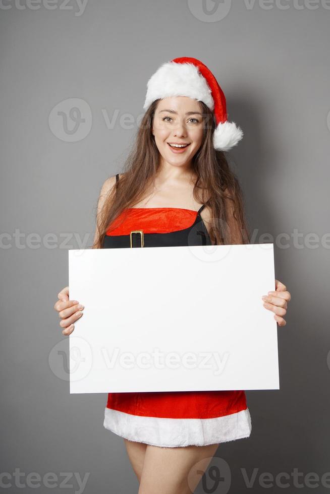 miss santa présentant une pancarte vierge avec espace de copie photo