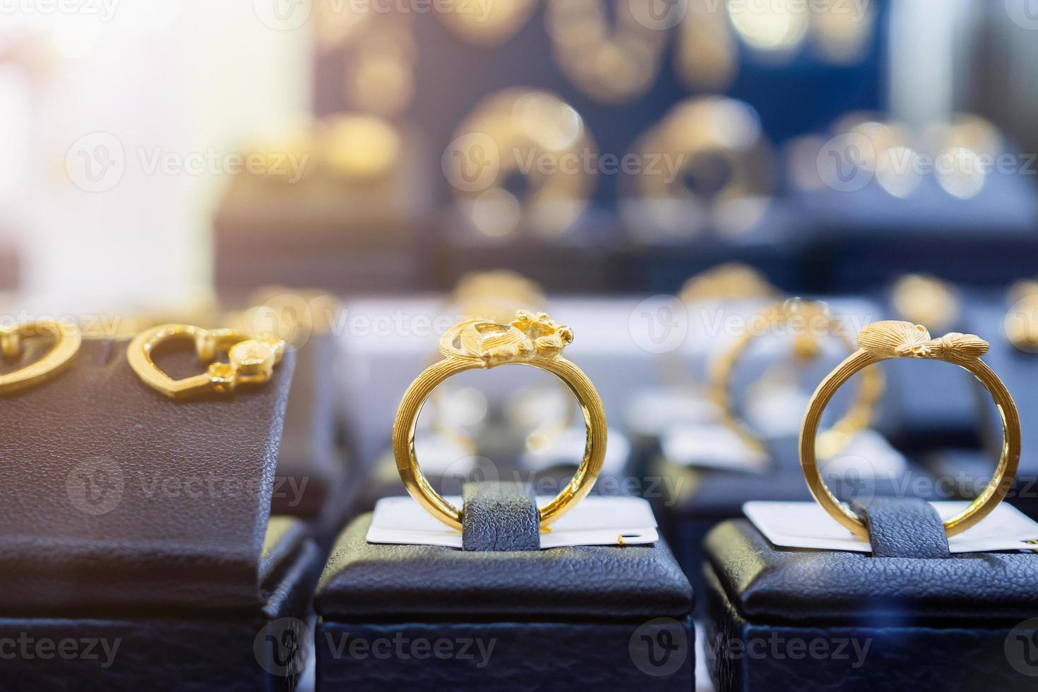 bijoux bagues dorées boucles d'oreilles et colliers montrent dans la vitrine d'affichage de vitrine de magasin de détail de luxe photo