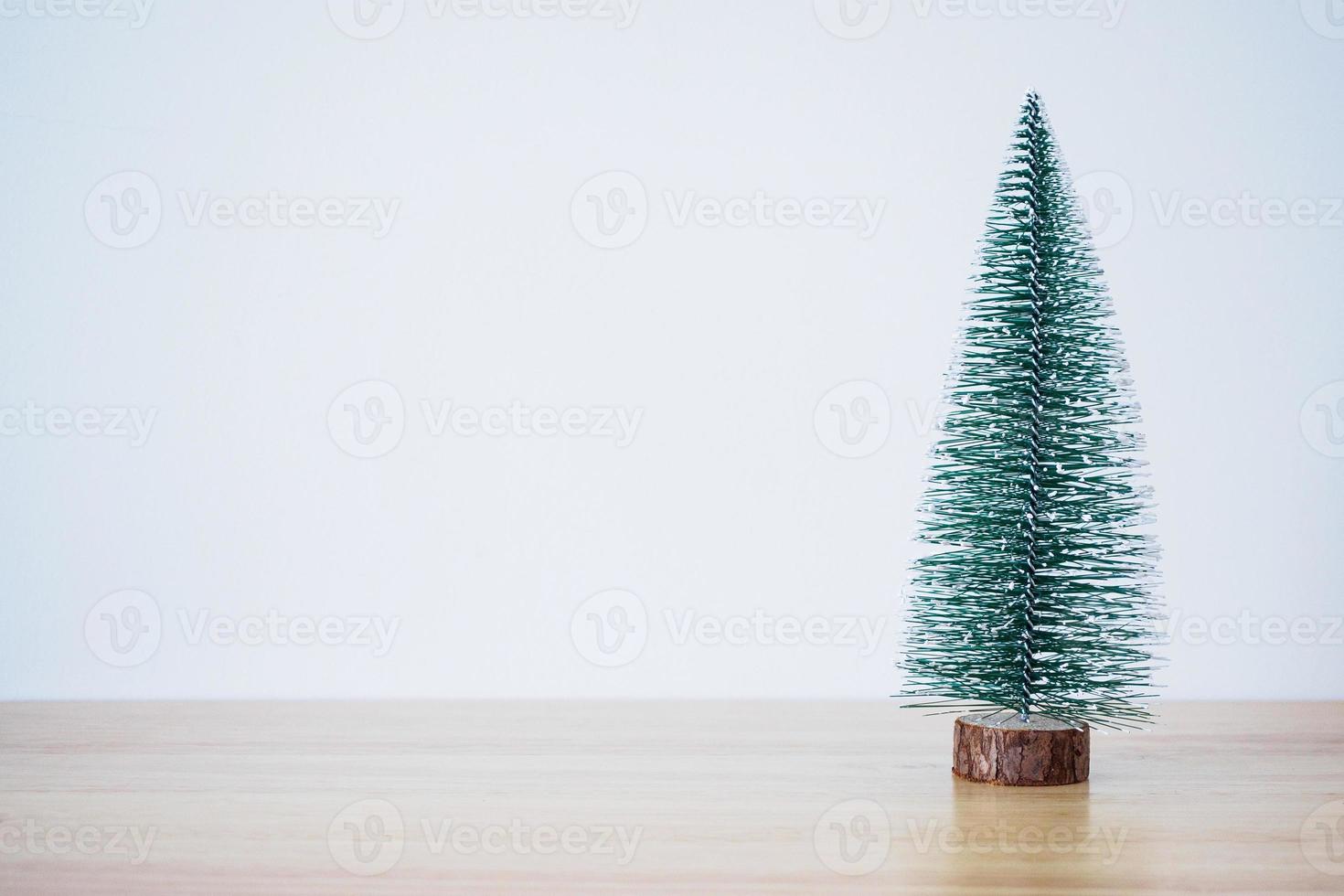 arbre de noël sur table en bois avec fond de mur blanc photo