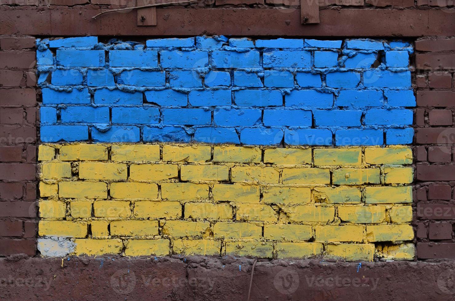 vieux mur de briques peint aux couleurs du drapeau ukrainien photo