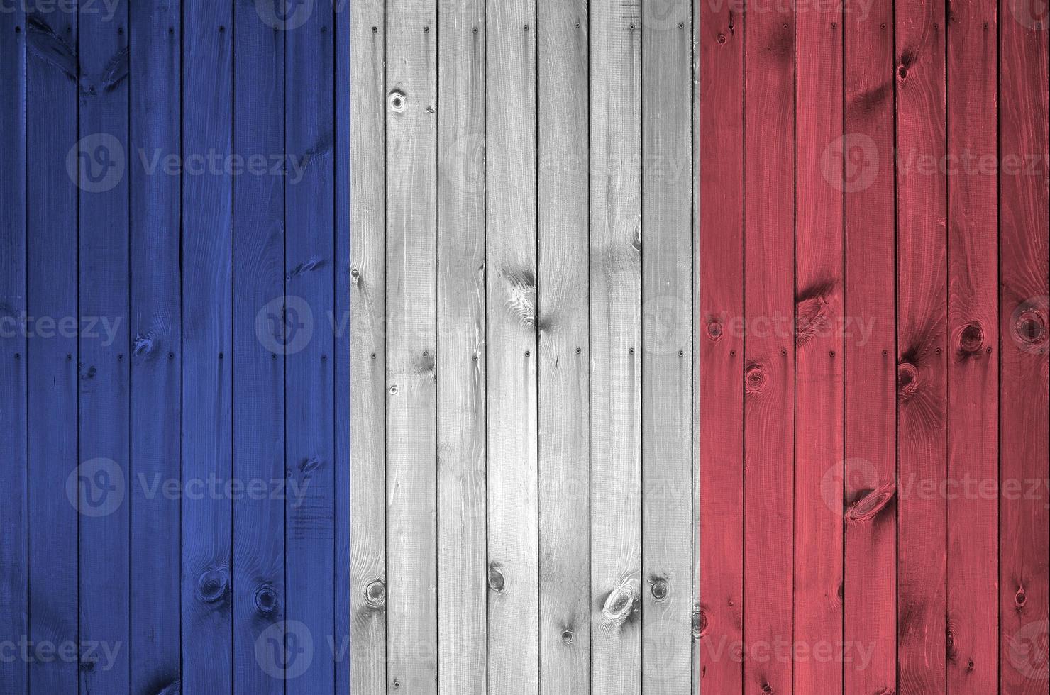 drapeau de la france représenté dans des couleurs de peinture vives sur un vieux mur en bois. bannière texturée sur fond rugueux photo