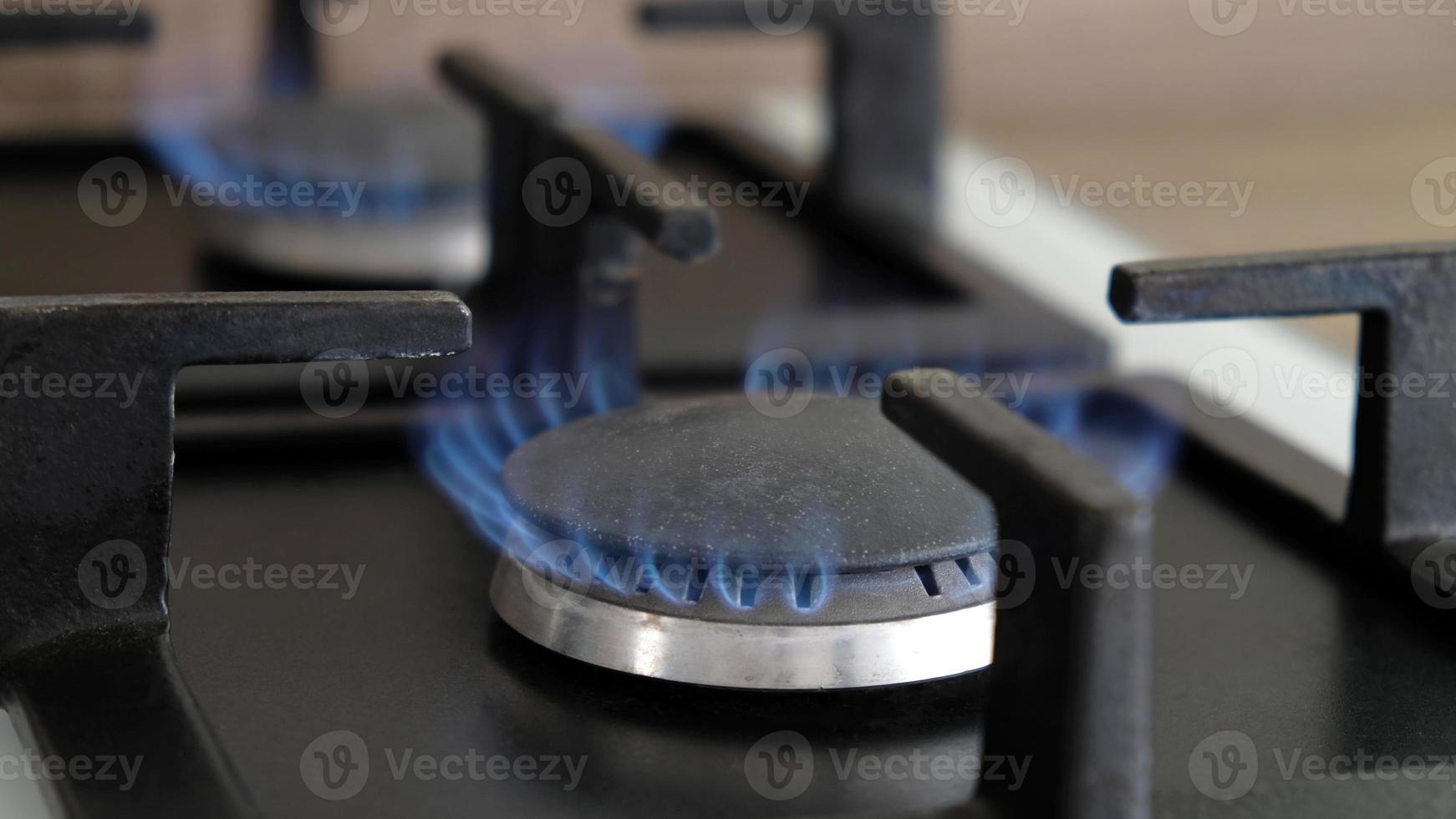 gros plan des flammes bleues du feu sur un brûleur à gaz dans la cuisine pour la cuisson. flamme de gaz dans une chaudière à gaz photo