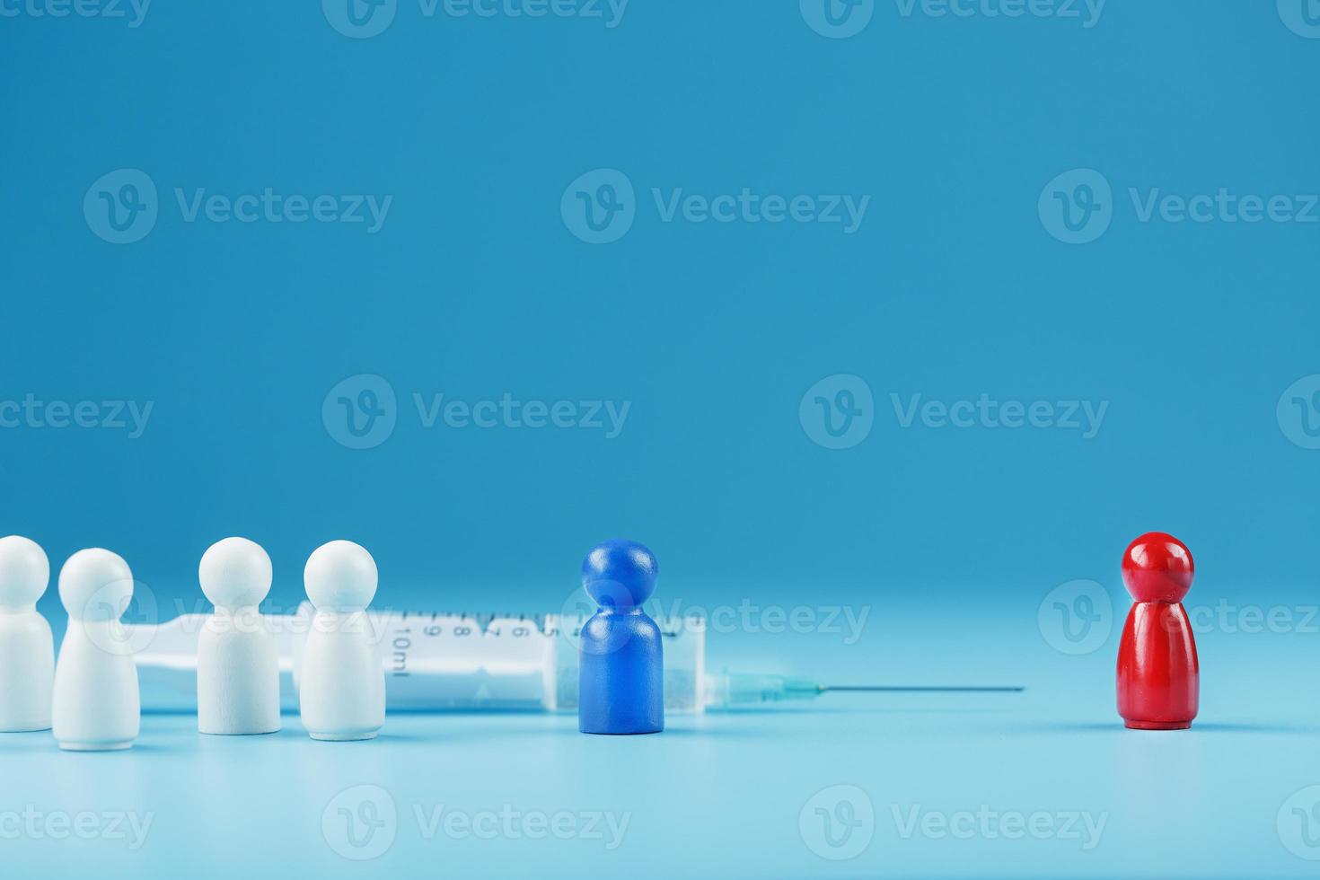 vacciner ou refuser une seringue avec un vaccin avec deux groupes de personnes un modèle humain rouge et bleu. photo