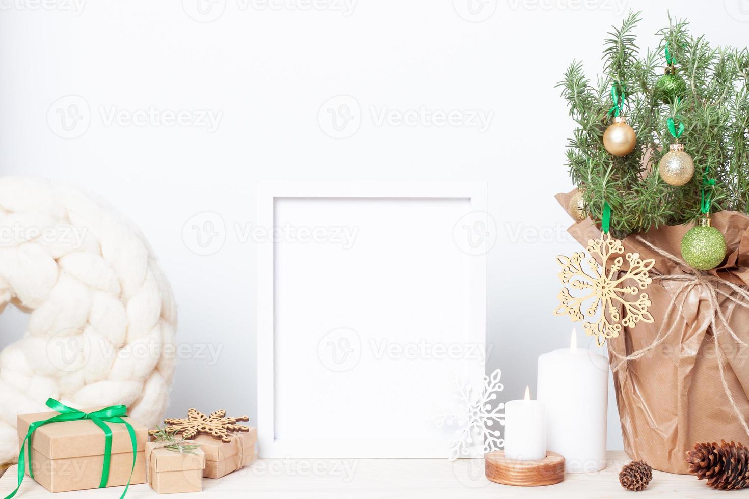 décoration naturelle de noël zéro déchet avec du romarin comme arbre de noël alternatif et un cadre de maquette blanc sur la table. gros plan, espace de copie photo