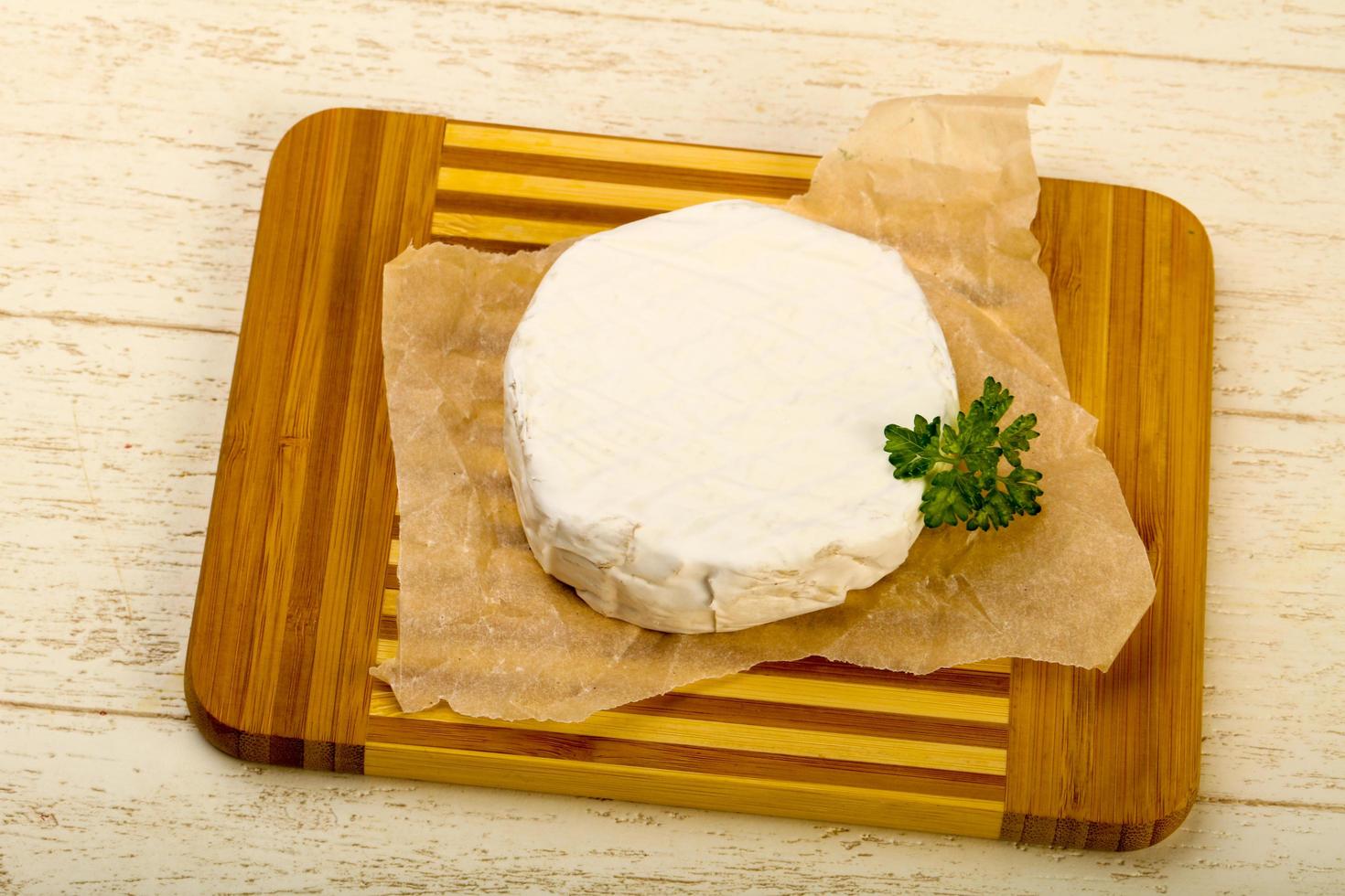 Fromage camembert sur planche de bois et fond de bois photo