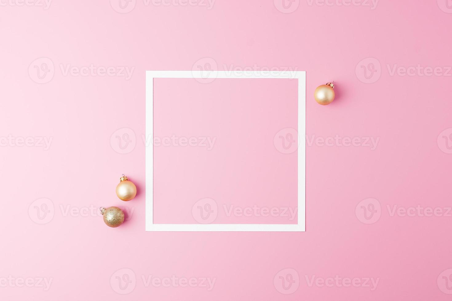 fond minimal de noël rose avec cadre blanc et boule beige. mise à plat, espace de copie photo