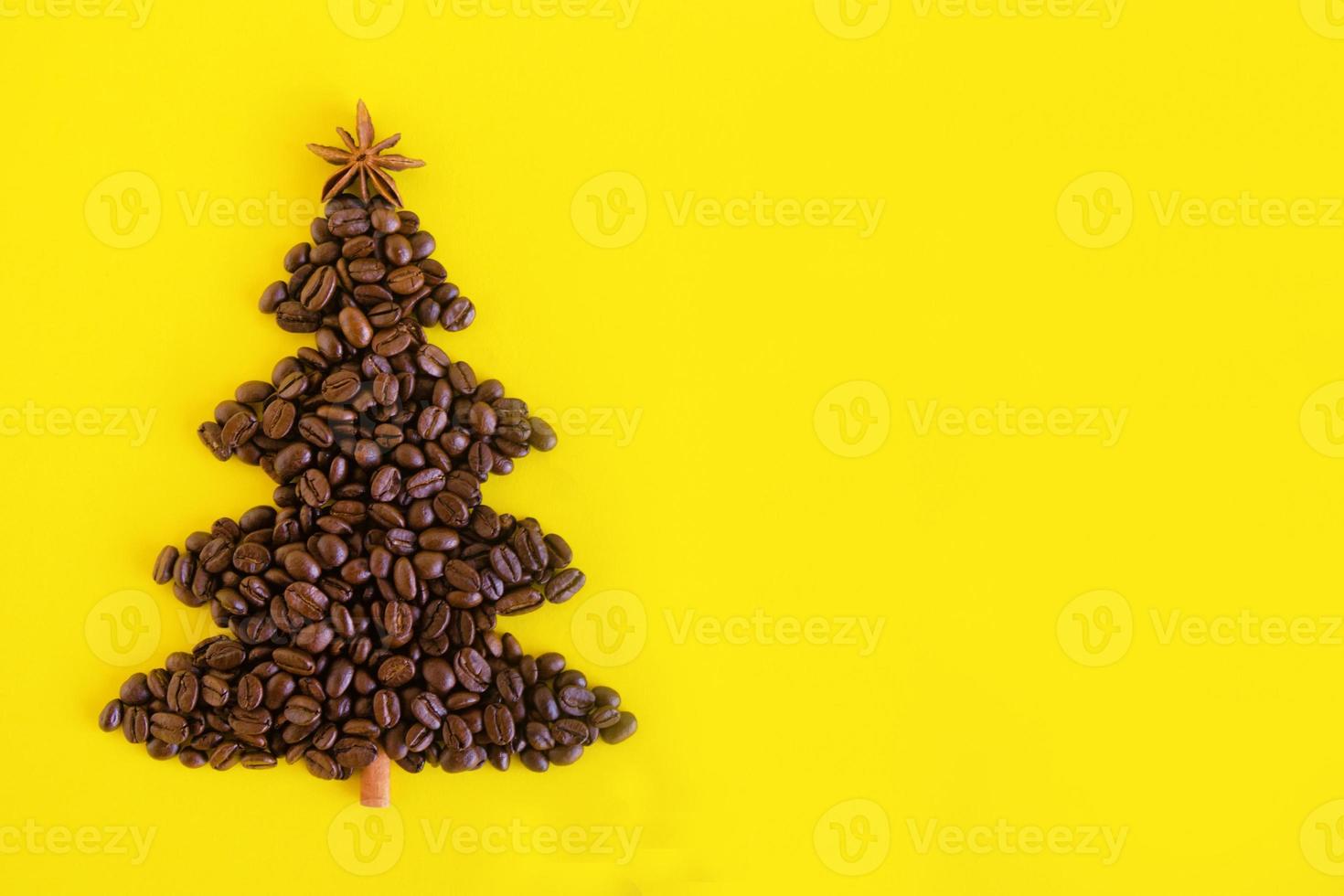 composition d'hiver avec arbre de noël fait de grains de café et étoile d'anis décorée et bâton de cannelle sur fond jaune, plat. carte de voeux pour le nouvel an avec espace de copie. photo