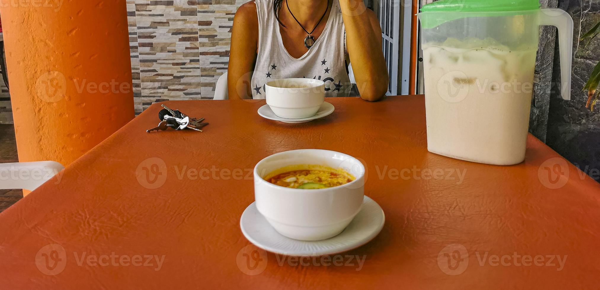 soupe de légumes aux carottes oignons verts tomate dans un bol blanc. photo