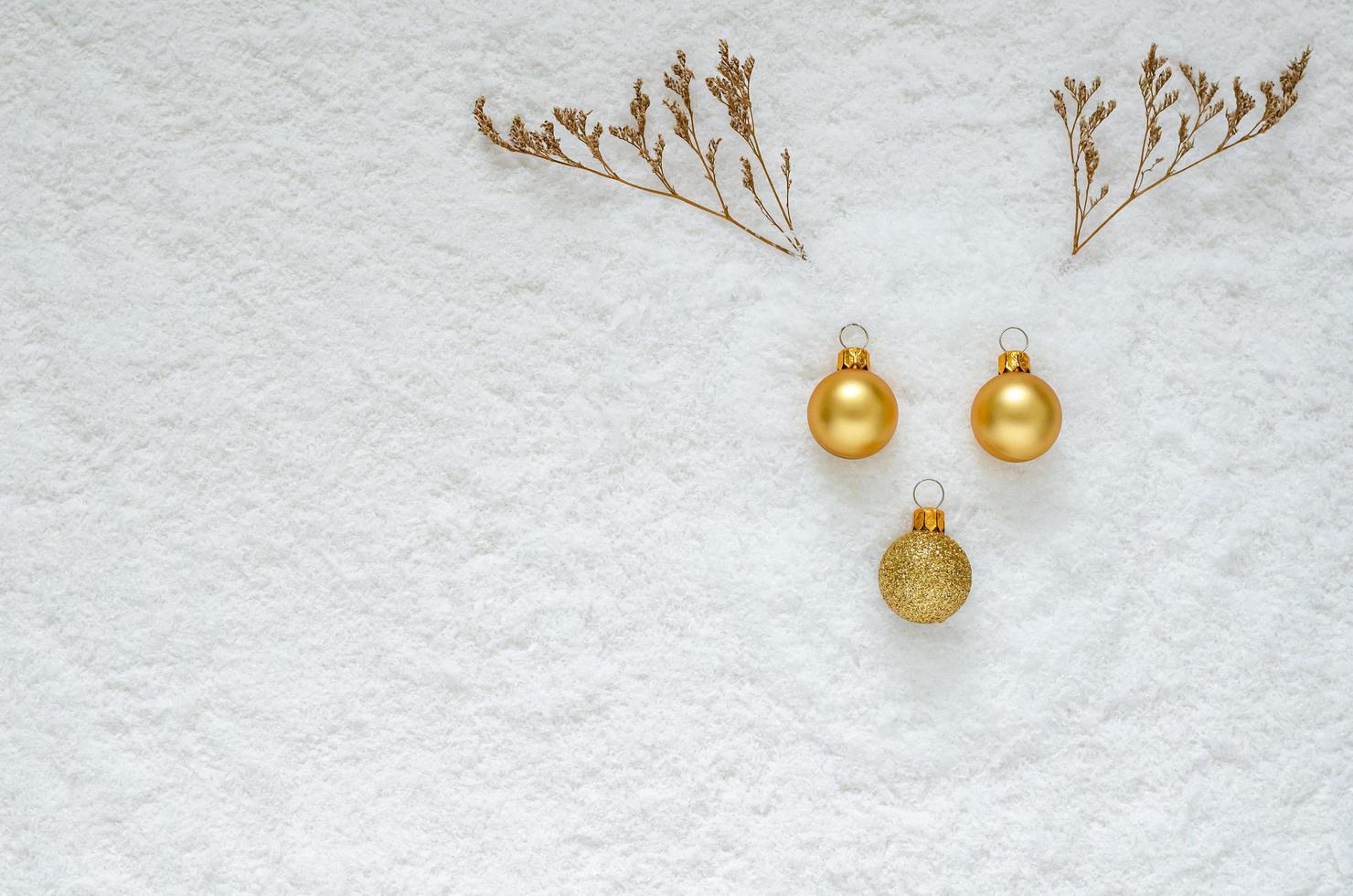 mise à plat du visage de renne avec des ornements de noël et arbre séché mis sur fond de neige. photo