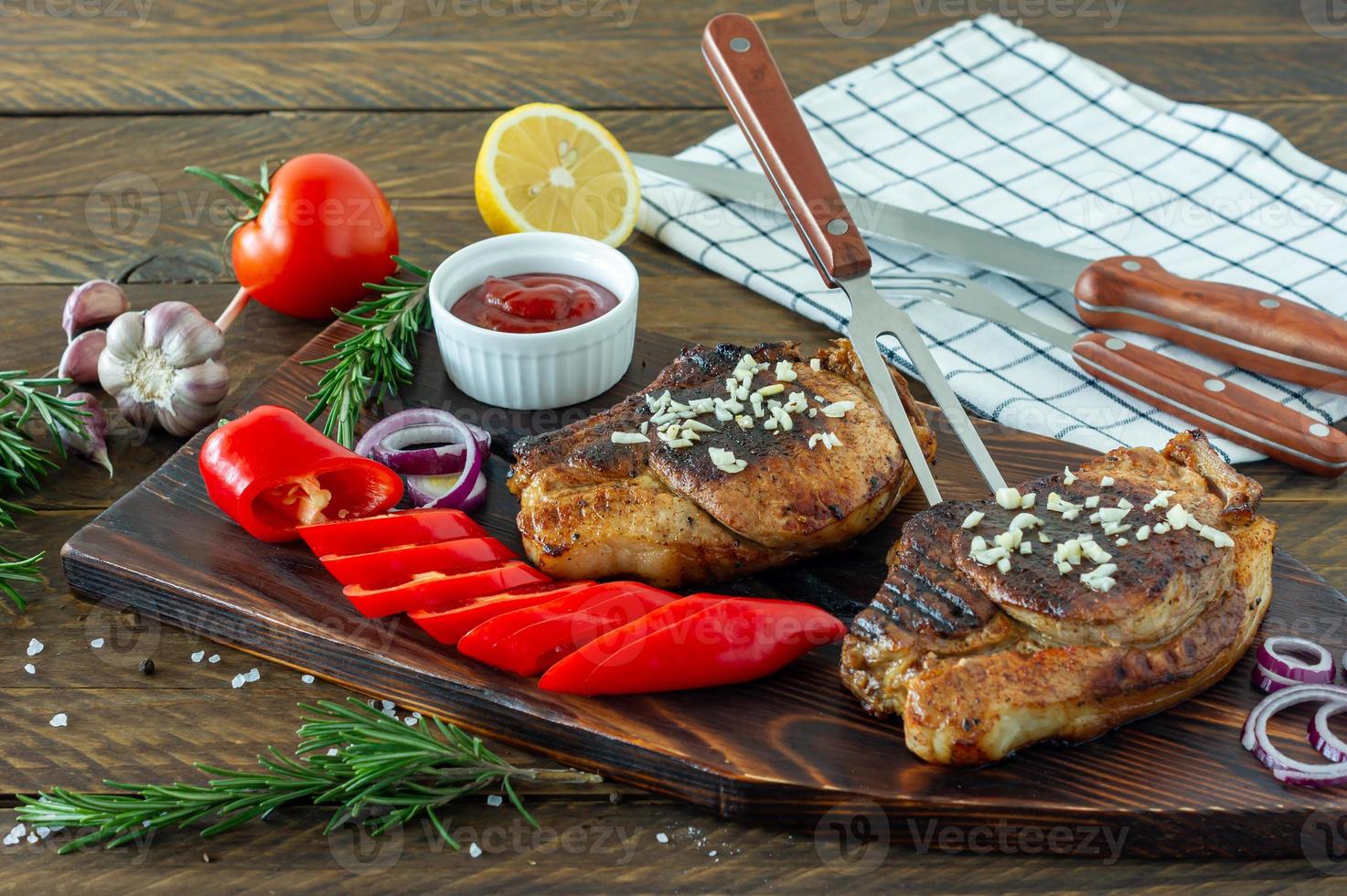 viande rouge rôtie juteuse fraîche sur planche de bois, avec épices et légumes. nourriture de restaurant, plat délicieux photo