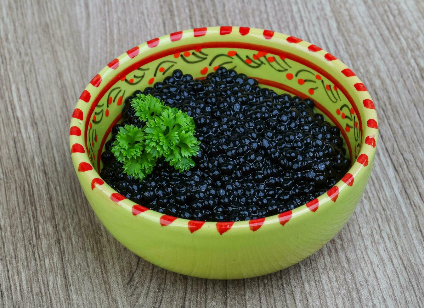 caviar noir dans un bol sur fond de bois photo