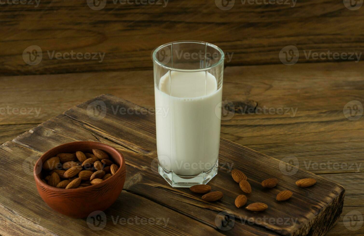 lait d'amande en verre avec des amandes sur une table en bois photo