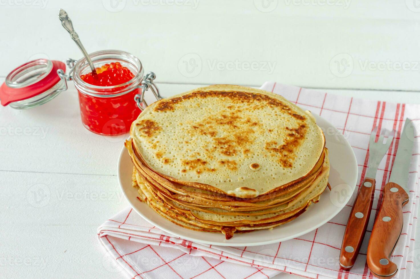 Blini de crêpes russes traditionnelles empilées dans une assiette avec du caviar rouge sur fond de bois. maslenitsa repas traditionnel du festival russe. cuisine russe, cuisine russe. fermer. photo