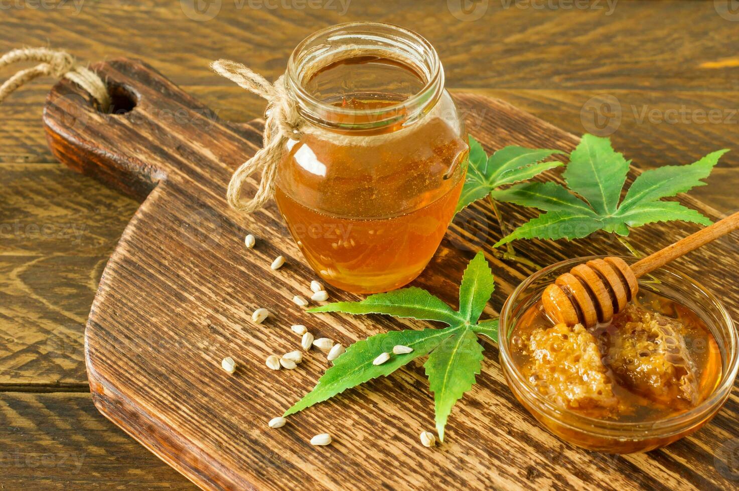 miel biologique frais avec des feuilles et des graines de cannabis plus profondes et sur une table en bois. alimentation saine médecine alternative photo