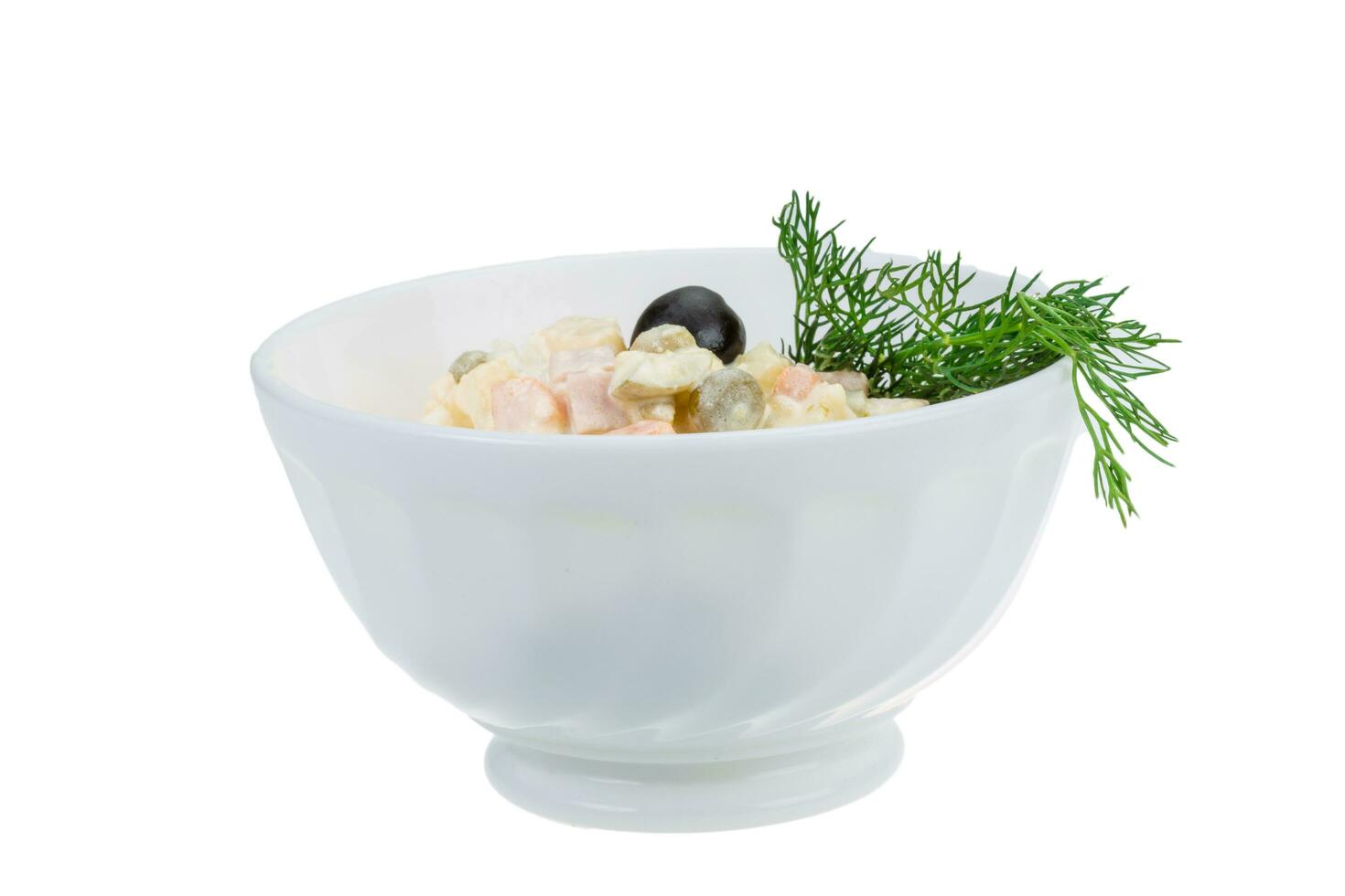 Salade russe dans un bol sur fond blanc photo