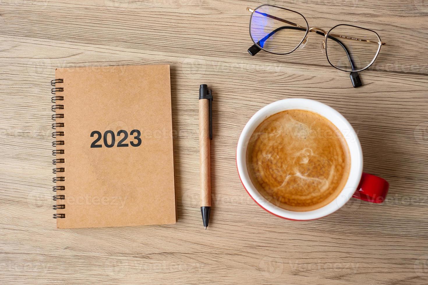 Cahier 2023 et tasse à café sur table en bois, vue de dessus et espace de copie. noël, bonne année, objectifs, résolution, liste de choses à faire, stratégie et concept de plan photo