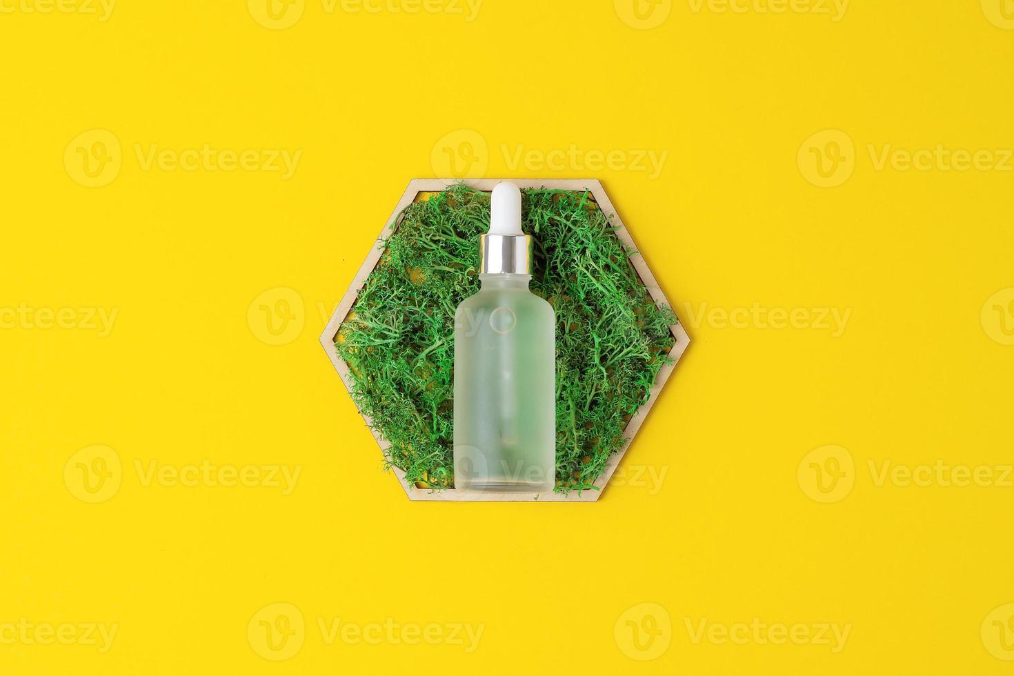 bouteille cosmétique avec un hexagone en bois et de la mousse sur fond jaune. mise à plat, espace de copie photo