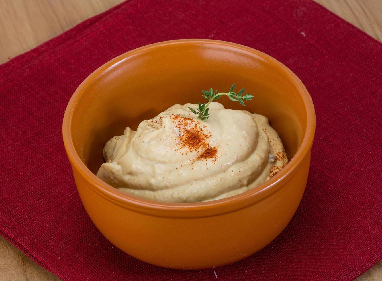 Houmous dans un bol sur fond de bois photo