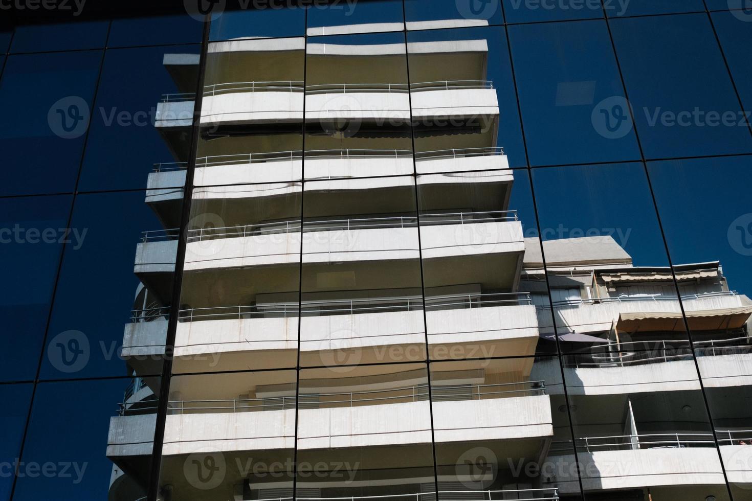 conception d'immeuble de bureaux moderne, géométrie de façade avec réflexion, répétition de fenêtres en verre bleu, motif, symétrie architecturale géométrique, architecture urbaine minimaliste. photo