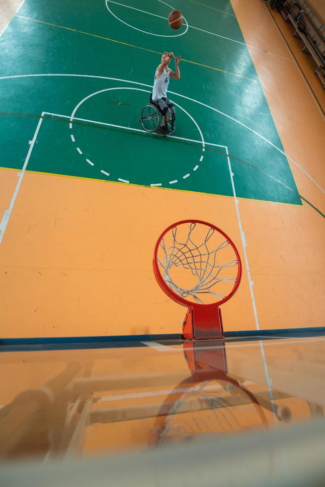 Voir la photo d'un vétéran de la guerre jouant au basket-ball dans une arène sportive moderne. le concept de sport pour les personnes handicapées