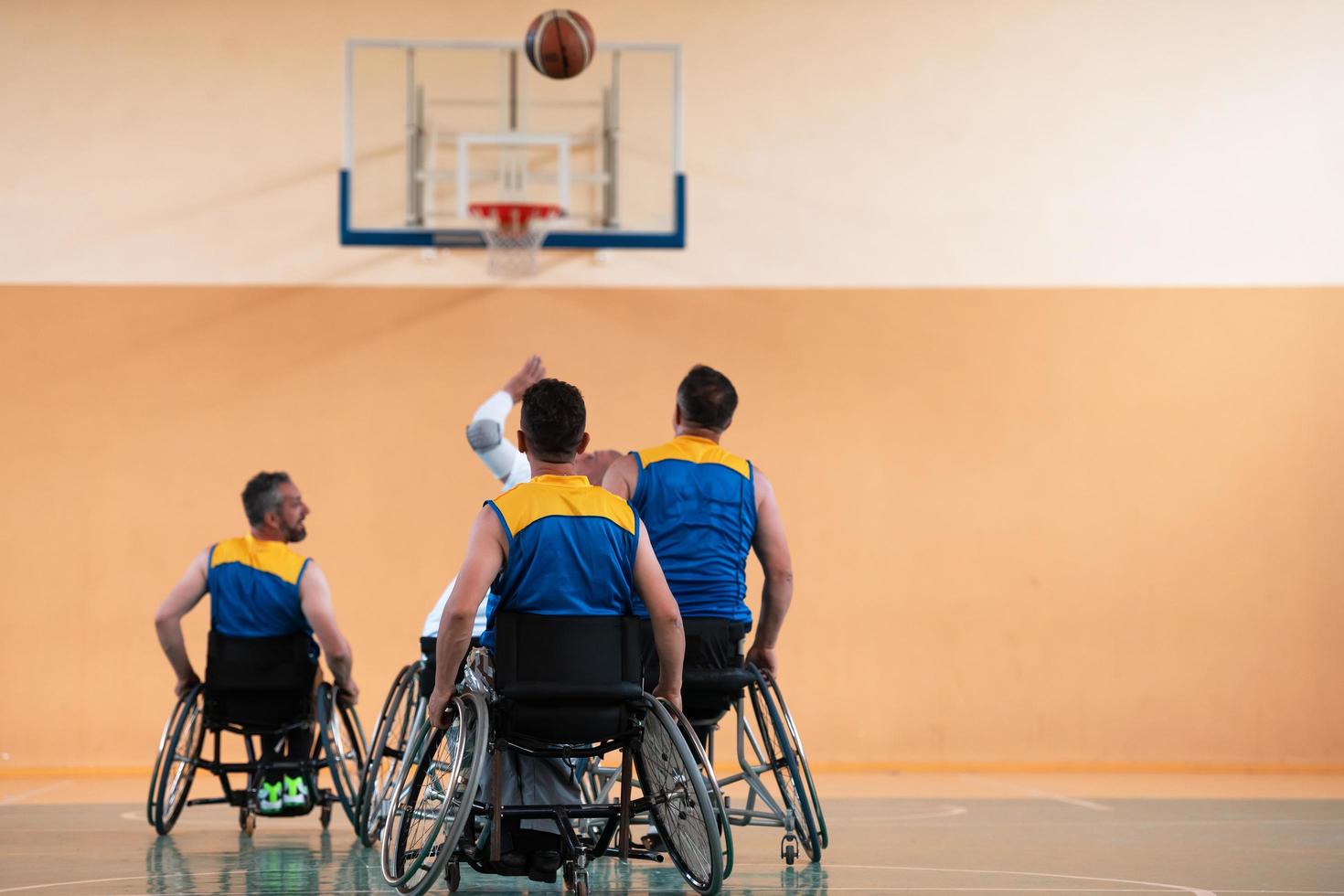 Anciens combattants handicapés de guerre mixtes et équipes de basket-ball d'âge en fauteuil roulant jouant un match d'entraînement dans une salle de sport. concept de réadaptation et d'inclusion des personnes handicapées photo