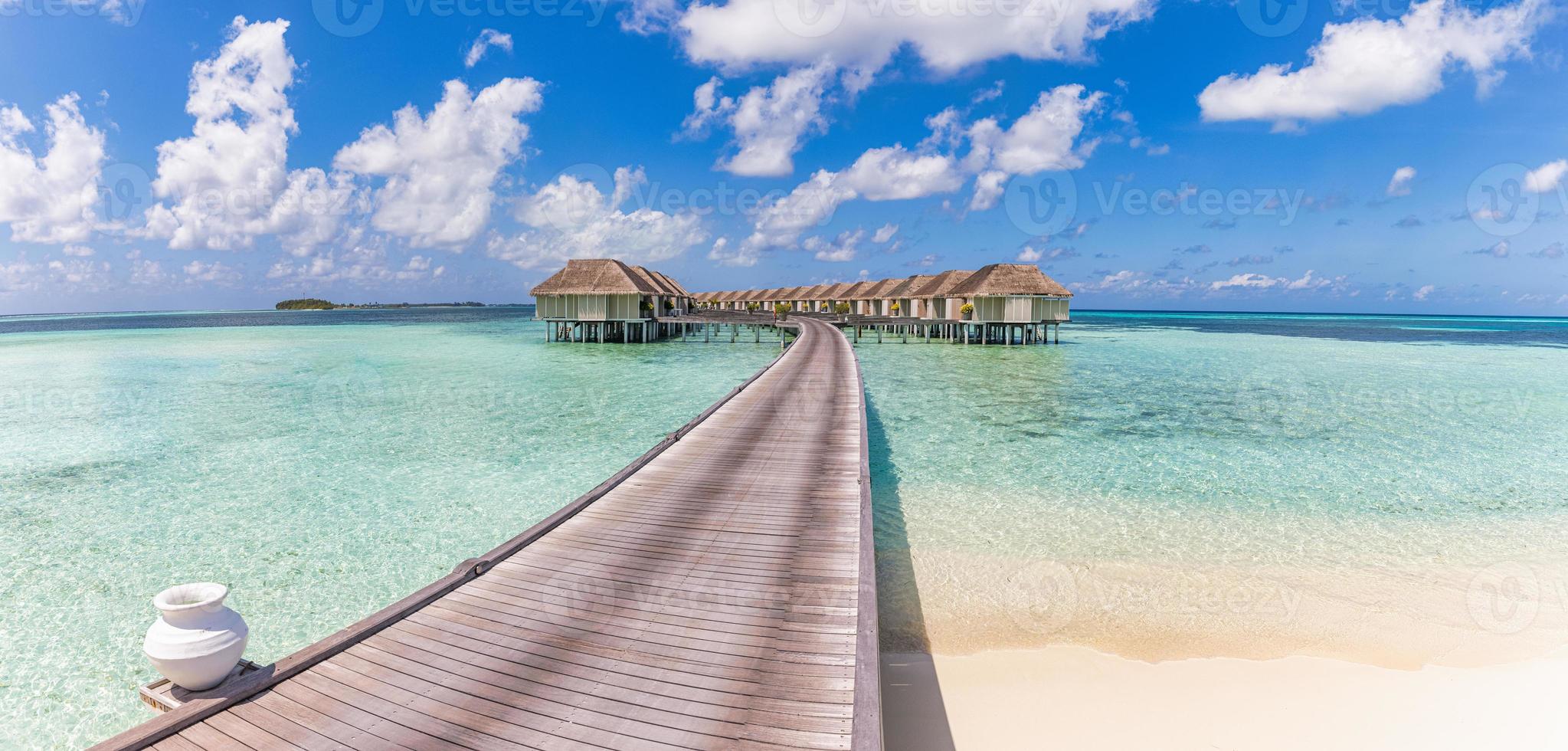 belle villa sur l'eau des maldives dans le lagon bleu et l'espace ciel bleu. paysage d'été panoramique, lagon océanique avec un ciel bleu nuageux idyllique relaxant. fond de voyage de luxe exotique. vue imprenable sur les maldives photo