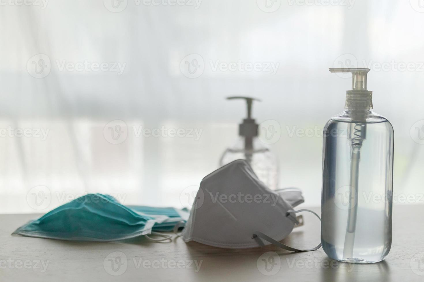 masque facial médical avec gel désinfectant à l'alcool lavage des mains sur table en bois pour le concept de prévention du coronavirus covid-19 photo