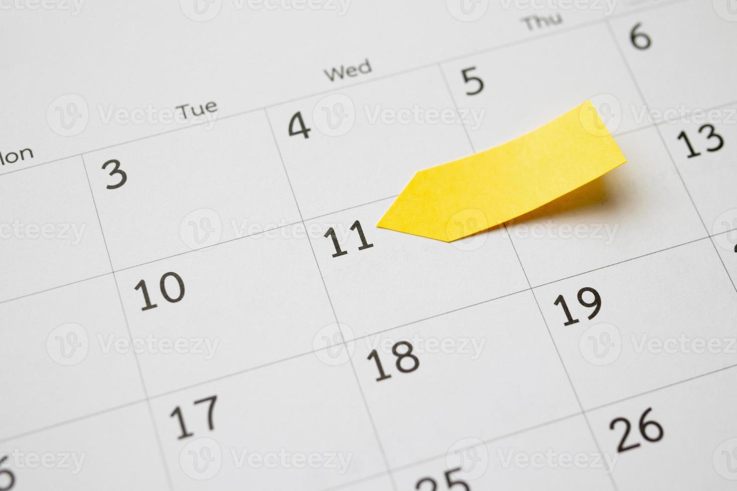 Planificateur de papier post-note adhésif jaune blanc avec espace sur fond de page de calendrier pour le concept de réunion de rendez-vous de planification d'entreprise photo