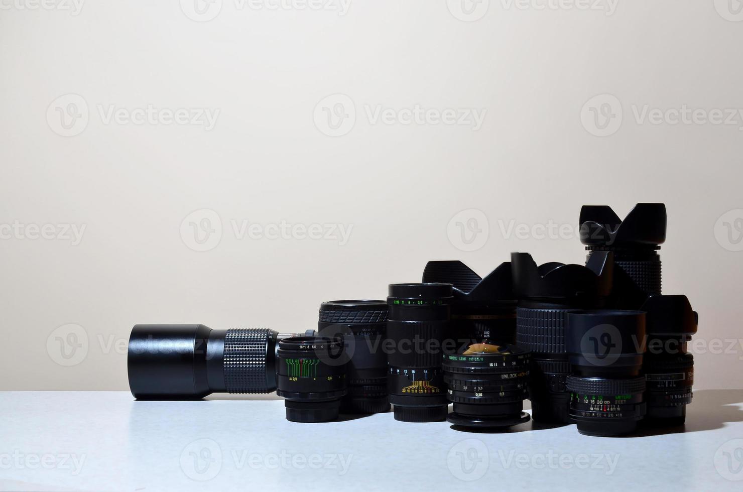 de nombreux objectifs professionnels différents pour appareil photo reflex se trouvent sur un bureau incolore