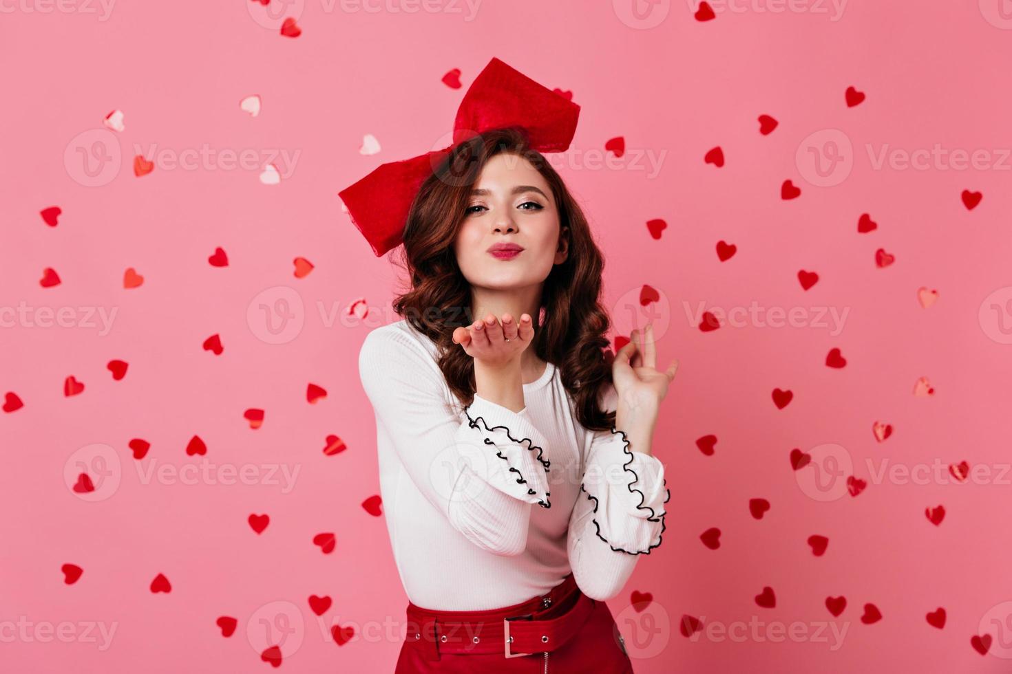 fille raffinée envoyant un baiser aérien. photo de studio de dame romantique isolée sur rose.