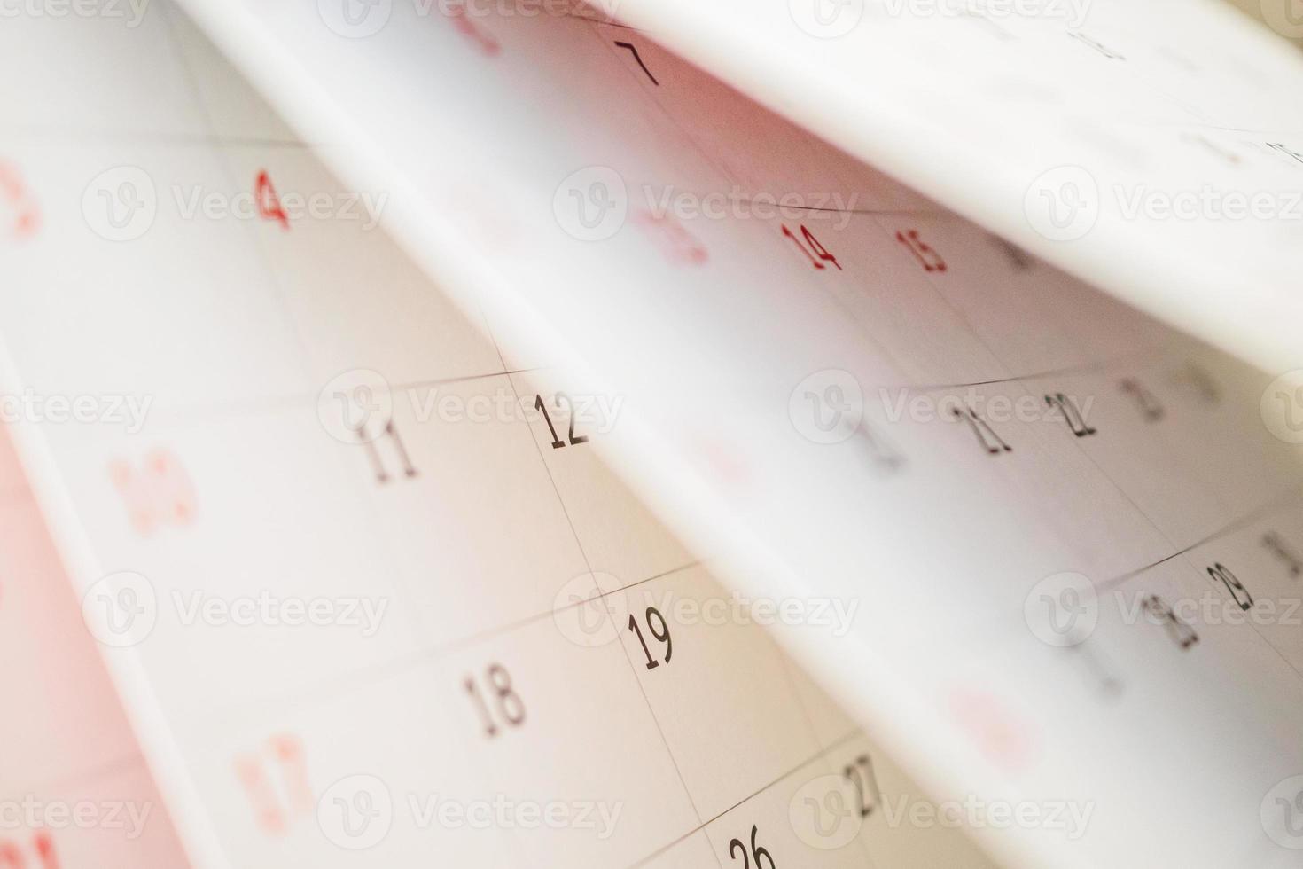 feuille de retournement de page de calendrier gros plan sur fond de table de bureau concept de réunion de rendez-vous de planification d'horaire d'entreprise photo