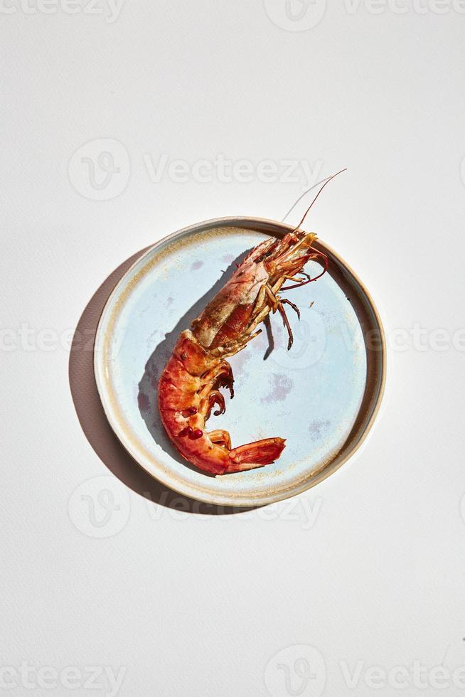 Crevettes préparées sur plaque sur fond clair photo